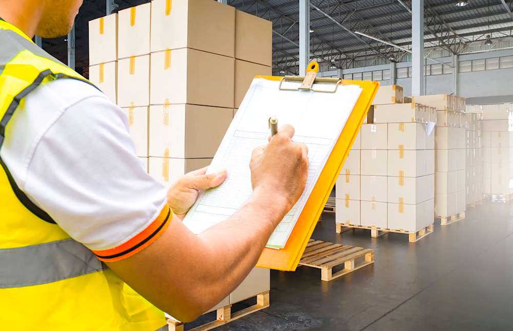 Inspector checking product with quality control checklist in a factory in 2025